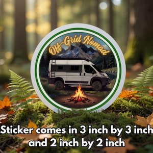 Op de afbeelding: Een ronde sticker met een witte campervan, een kampvuur en bergen op de achtergrond, met de tekst "Off-Grid Nomad". Beschikbaar in formaten van 7.6 cm x 7.6 cm en 5 cm x 5 cm.