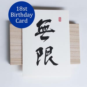 Könnte beinhalten: Eine weiße Karte mit schwarzer Kalligraphie, die auf einem Holzblock liegt. Die Karte zeigt zwei große chinesische Schriftzeichen und einen kleinen roten Stempel. Ein blauer Kreis mit dem Text "18th Birthday Card" befindet sich oben links.