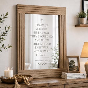 May include: A large, rectangular wooden mirror with a decorative frame. The mirror reflects text that reads "TRAIN UP A CHILD IN THE WAY THEY SHOULD GO..." A wooden bowl, candle, and decorative beads sit on a wooden surface.