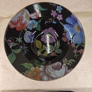 May include: A black ceramic bowl with a floral pattern. The bowl displays colourful flowers in shades of red, blue, purple, and yellow. The rim has a gold trim. The bowl is likely used for serving food.