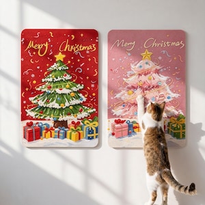 May include: Two rectangular wall hangings featuring Merry Christmas text. The left panel is red with a green Christmas tree and colorful gifts. The right panel is pink with a white Christmas tree and gifts, with a cat reaching toward it.