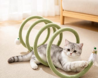 May include: A light green, plush, spiral-shaped cat tunnel toy with a soft texture. The tunnel features a small white pom-pom at one end and a dangling white feather with a small gold bell at the other end, with a cat resting inside.