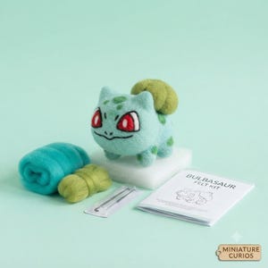 Puede incluir: Un kit de fieltro con aguja que incluye una criatura verde claro con un bulbo verde oscuro en la espalda, ojos rojos y manchas verde oscuro. Incluye lana cardada verde azulado y verde, dos agujas en un estuche y un folleto Bulbasaur Felt Kit.