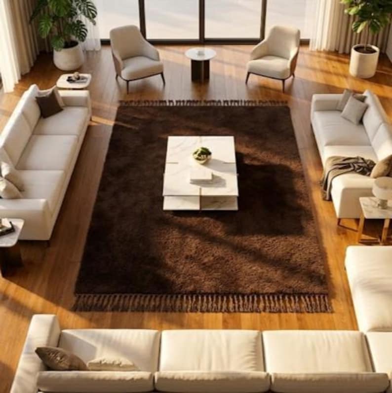 Premium chocolate brown hand-knotted rug made of 100% New Zealand wool, featuring a solid contemporary design with contrasting fringed edges, styled under a mid-century coffee table in a modern minimalist living room.