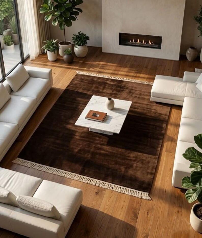 Premium chocolate brown hand-knotted rug made of 100% New Zealand wool, featuring a solid contemporary design with contrasting fringed edges, styled under a mid-century coffee table in a modern minimalist living room.