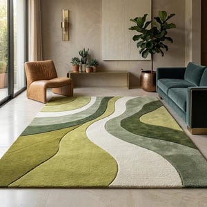 Könnte beinhalten: Ein großer, rechteckiger Teppich mit einem wellenförmigen Design in Grün- und Weißtönen. Der Teppich befindet sich in einem Wohnzimmer, mit einem grünen Sofa, einem braunen Stuhl und Topfpflanzen im Hintergrund. Das Design des Teppichs verleiht dem Raum eine moderne Note.