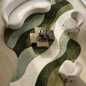 Könnte beinhalten: Draufsicht auf ein modernes Wohnzimmer mit einem großen, wellenförmigen grünen und cremefarbenen Teppich. Ein geschwungenes cremefarbenes Sofa und zwei passende Sessel umgeben einen quadratischen Couchtisch. Dekorative Vasen und eine Stehlampe vervollständigen das stilvolle Interieur.