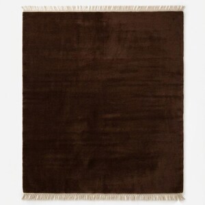 Premium chocolate brown hand-knotted rug made of 100% New Zealand wool, featuring a solid contemporary design with contrasting fringed edges, styled under a mid-century coffee table in a modern minimalist living room.