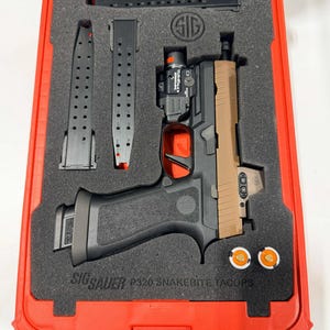Könnte beinhalten: Eine schwarze und hellbraune Handfeuerwaffe mit Zubehör, darunter Magazine und eine Lampe, wird in einem roten Koffer präsentiert. Die Handfeuerwaffe hat einen schwarzen Griff und einen hellbraunen Schlitten. Der Koffer ist mit "SIG SAUER P320 SNAKEBITE TACOPS" beschriftet.