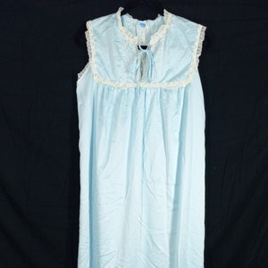 May include: A light blue sleeveless nightgown with white lace trim around the neckline and armholes. The gown has a tie at the neckline.
