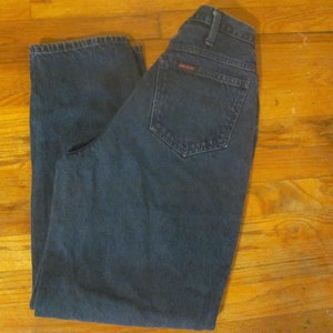 May include: A pair of dark blue denim jeans with a red