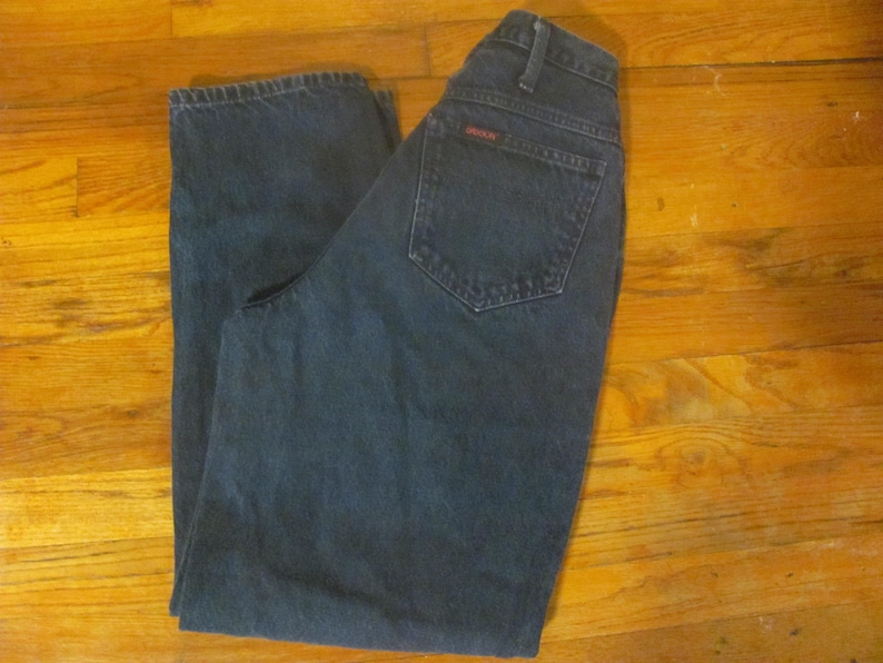 May include: A pair of dark blue denim jeans with a red