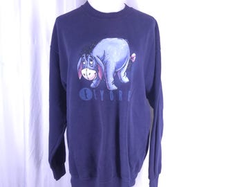 May include: A navy blue sweatshirt with a cartoon image of Eeyore the donkey from Winnie the Pooh. The text "Eeyore" is printed below the image.
