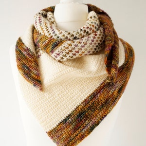May include: A triangular crocheted shawl with a cream coloured base and a multi-coloured border. The border features shades of brown, orange, green, and purple.