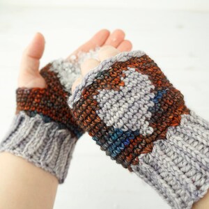 May include: A pair of gray and brown fingerless gloves with a colorful geometric pattern. The gloves are knitted and have a textured surface.