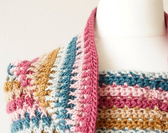 May include: A crocheted cowl with a striped pattern in shades of pink, teal, beige, and brown. The cowl is displayed on a white mannequin.