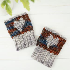 May include: A pair of gray and brown crocheted wrist warmers with a white heart design.