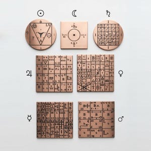 Pode incluir: Uma coleção de sete placas de metal na cor cobre com padrões geométricos gravados, grades e caracteres alfanuméricos. O conjunto inclui três placas circulares e quatro quadradas, cada uma marcada com símbolos distintos e ícones planetários.
