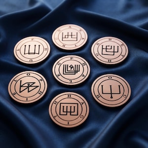 May include: Seven circular copper-toned metal coins arranged in a cluster. Each coin features a unique black engraved geometric sigil in the center, surrounded by a circular border containing individual black capital letters spelling out names.