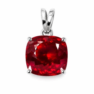 May include: A cushion-cut vibrant red gemstone pendant set in a polished silver-toned metal frame. The square-shaped stone features multifaceted surfaces that reflect light, held by four small prongs and topped with a silver-toned metal bail.