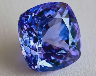 May include: A square-cut gemstone with facets reflecting shades of blue and purple. The gem is set against a white background, showcasing its clarity and brilliance. This gemstone is ideal for jewelry.
