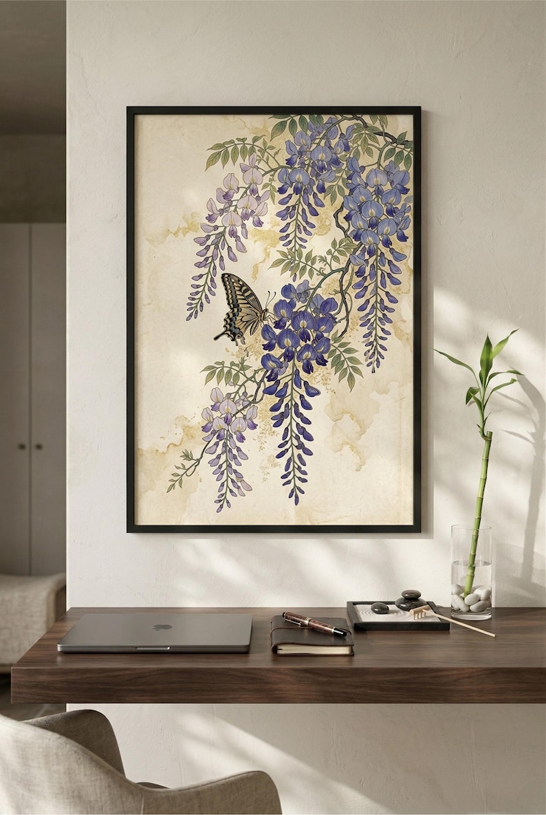 K&ouml;nnte beinhalten: Gerahmter Kunstdruck mit einem Schmetterling auf einem Blauregenzweig mit lila und lavendelfarbenen Bl&uuml;ten. Das Kunstwerk hat eine Vintage-&Auml;sthetik mit neutralem Hintergrund und wird auf einem Holzschreibtisch pr&auml;sentiert.