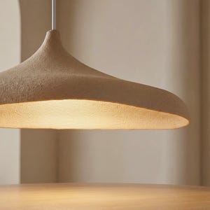 Op de afbeelding: Een set van drie keramische mokken met een gespikkelde, matte afwerking. De mokken zijn in cr&egrave;me, lichtgrijs en donkergrijs. Elke mok heeft een eenvoudig, minimalistisch ontwerp en een afgeronde handgreep.