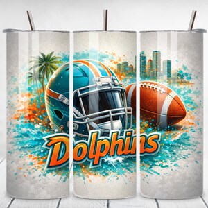 May include: A stainless steel tumbler featuring a teal football helmet with orange stripes and a brown football. The word "Dolphins" is displayed in orange and white. The design includes palm trees and a city skyline.