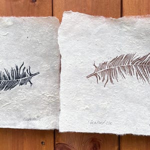 gold feather and black feather pair of linoprints on handmade paper