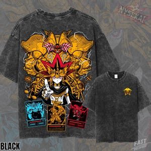 Puede incluir: Camiseta negra con un gráfico que representa un personaje con un tocado rojo y dorado, rodeado de figuras doradas y tres cartas de juego. También se ve una camiseta más pequeña con un emblema dorado. La palabra "BLACK" está en la parte inferior.