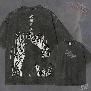 Op de afbeelding: Een antracietgrijs acid-wash T-shirt met een witte afbeelding op de achterkant van een silhouet in hoog gras met de tekst ARISE. Op de borst staat de witte tekst Solo Leveling in een gestileerd lettertype.