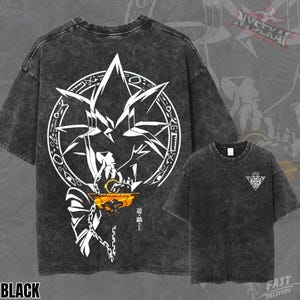 Op de afbeelding: Zwart T-shirt met een wit grafisch ontwerp op de voorkant en een kleinere versie op de borst. Het ontwerp heeft een stervorm, een figuur en Japanse tekst. Het shirt heeft een gewassen, vintage uitstraling.