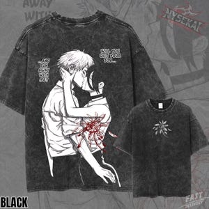 Può includere: Una t-shirt nera lavaggio acido con una grande illustrazione in stile manga sul retro raffigurante due personaggi che si baciano, con il testo "...AND RUN AWAY WITH ME?" e "WILL YOU QUIT YOUR JOB...". Il davanti presenta un piccolo motivo floreale bianco.