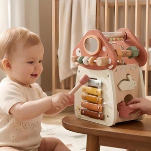 以下が含まれることがあります： 木製の知育キューブ。木琴、ビーズ迷路、その他のインタラクティブな機能があります。 キューブはパステルカラーで塗装されており、キノコ型のトップが付いています。 子供がおもちゃで遊んでいます。