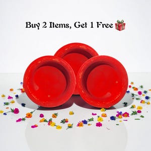 Puede incluir: Tres cuencos de cerámica redondos de color rojo brillante con un borde ancho están dispuestos sobre una superficie blanca, rodeados de coloridas flores secas. El texto "Buy 2 Items, Get 1 Free" está encima de los cuencos.