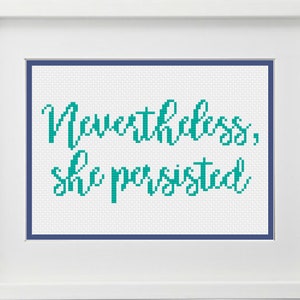 May include: Cross-stitch embroidery with a teal colored thread on white fabric. The text reads "Nevertheless, she persisted."