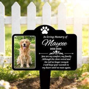 Pode incluir: Uma estaca de jardim memorial preta retangular com a foto de um golden retriever, um ícone de pata branca e o texto: In loving Memory of Maycee 2018-2026. Abaixo, um poema sobre conforto, garras e cauda até nos encontrarmos novamente.