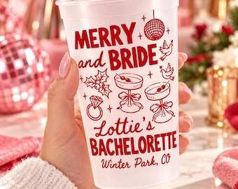 May include: A translucent white plastic cup featuring red printed text and graphics. The design includes a disco ball, doves, holly, a diamond ring, and two martini glasses. Text reads: MERRY and BRIDE, Lottie's BACHELORETTE, Winter Park, CO.