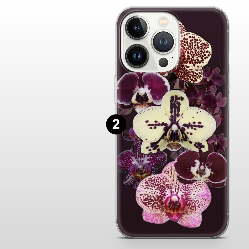 May include: A smartphone case with a floral design of orchids in shades of purple, white, and pink. The case has a dark purple background and a clear border. The orchids are arranged vertically.