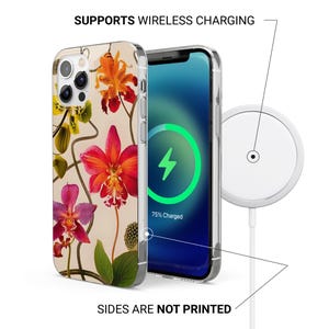 May include: A clear phone case with a floral design featuring red, orange, and purple orchids. The phone screen displays a charging symbol. The text reads: "SUPPORTS WIRELESS CHARGING" and "SIDES ARE NOT PRINTED". A white wireless charger is also shown.