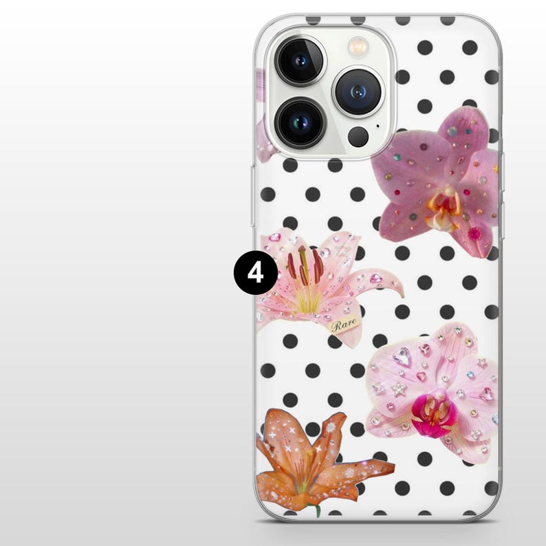 May include: Transparent phone case with a white backdrop and black polka dots. The case showcases pink and orange floral designs with rhinestone embellishments. The word "Rare" is printed on one of the flowers.