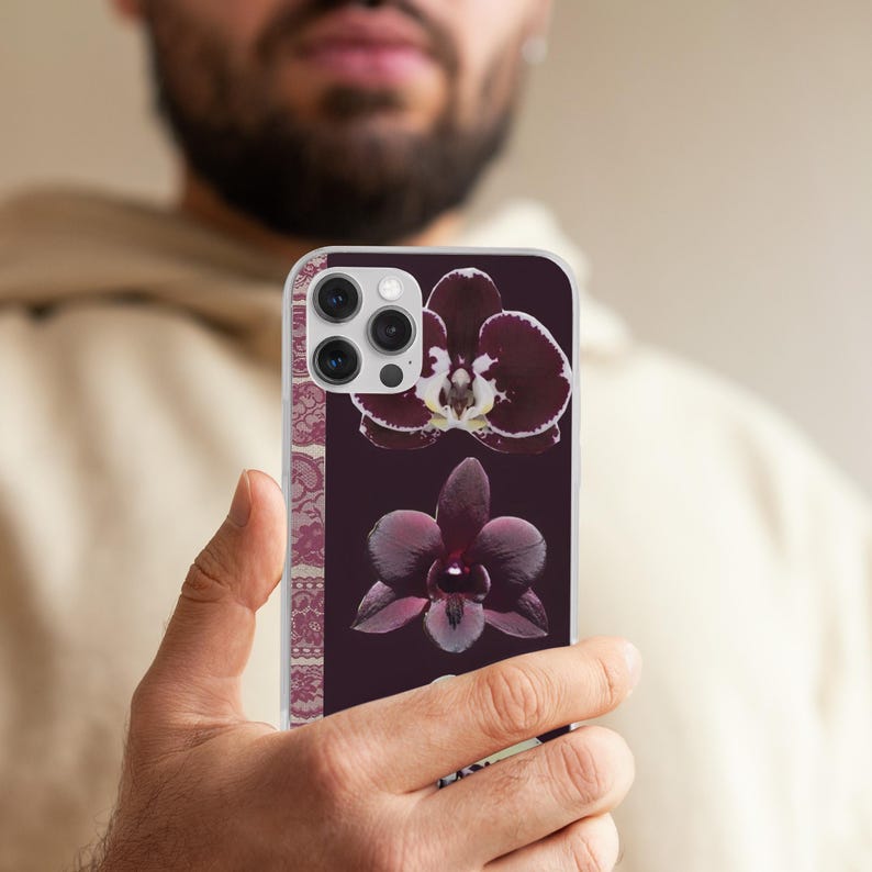 May include: A smartphone case displaying two dark purple orchid flowers on a deep burgundy backdrop. The case has a decorative floral pattern on the side and a clear border.