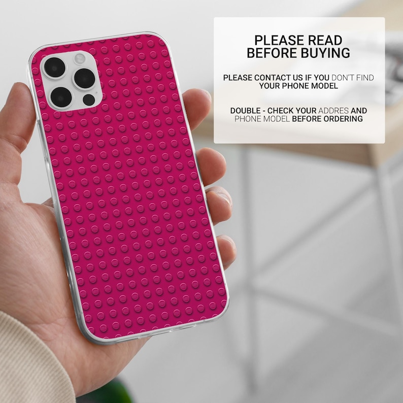 May include: A magenta phone case with a raised dot pattern, held in a hand. The case has a clear border and a camera cutout. Text on a white background reads "PLEASE READ BEFORE BUYING".