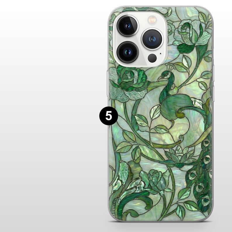 May include: A phone case with a green peacock and floral design. The case features a stained glass effect with shades of green, white, and a pearlescent finish. The design includes roses and leaves.