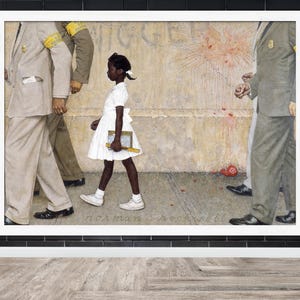 May include: A framed print of Norman Rockwell's painting, depicting a young Black girl in a white dress walking past U.S. Marshals. The girl carries books and is flanked by men in suits. The artwork is set against a textured wall.