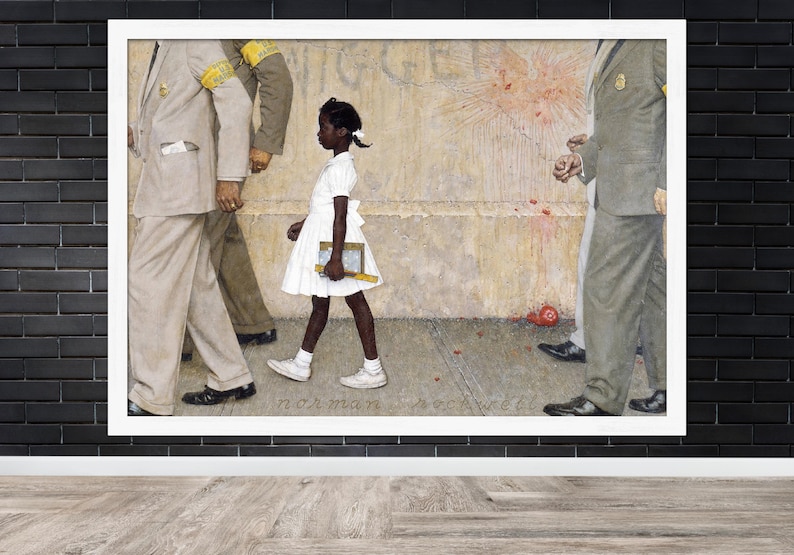May include: A framed print of Norman Rockwell's painting, depicting a young Black girl in a white dress walking past U.S. Marshals. The girl carries books and is flanked by men in suits. The artwork is set against a textured wall.