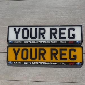 May include: Two rectangular vehicle number plates, one white and one yellow, both featuring the black text YOUR REG. The bottom black border displays the Subaru logo, the SPT logo, the text SUBARU PERFORMANCE TUNING, WRX, and the STI logo.