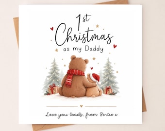 May include: A square greeting card featuring a brown bear wearing a red scarf and a smaller bear wearing a red Santa hat. The text reads 1st Christmas as my Daddy and Love you loads, from Bertie x, surrounded by illustrated pine trees and gifts.