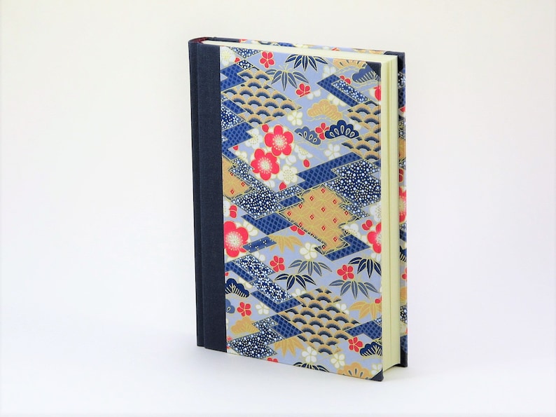 May include: A blue, gold, and red patterned hardcover journal with a dark blue spine.