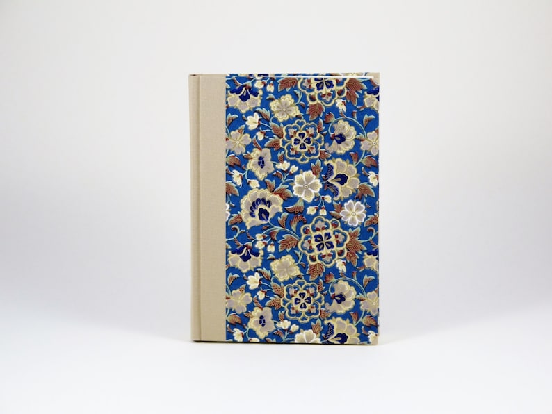 Pu&ograve; includere: Un diario blu e beige con un motivo floreale sulla copertina. Il diario ha una spina dorsale con uno sfondo beige.